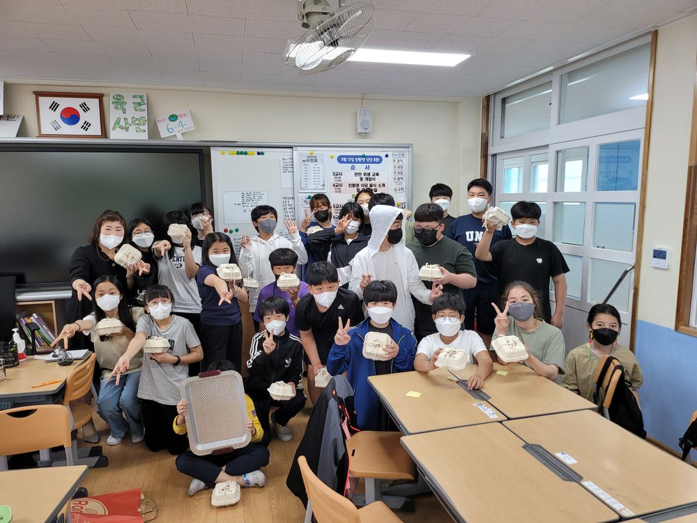 초등학교 교실에서 친환경 도시락 용기를 들고 함께 사진을 찍은 학생들
